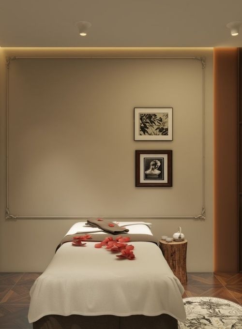 Serene massage treatment room at Luckin Spa Abu Dhabi, with a comfortable bed adorned with rose petals and a rustic side table for relaxation.